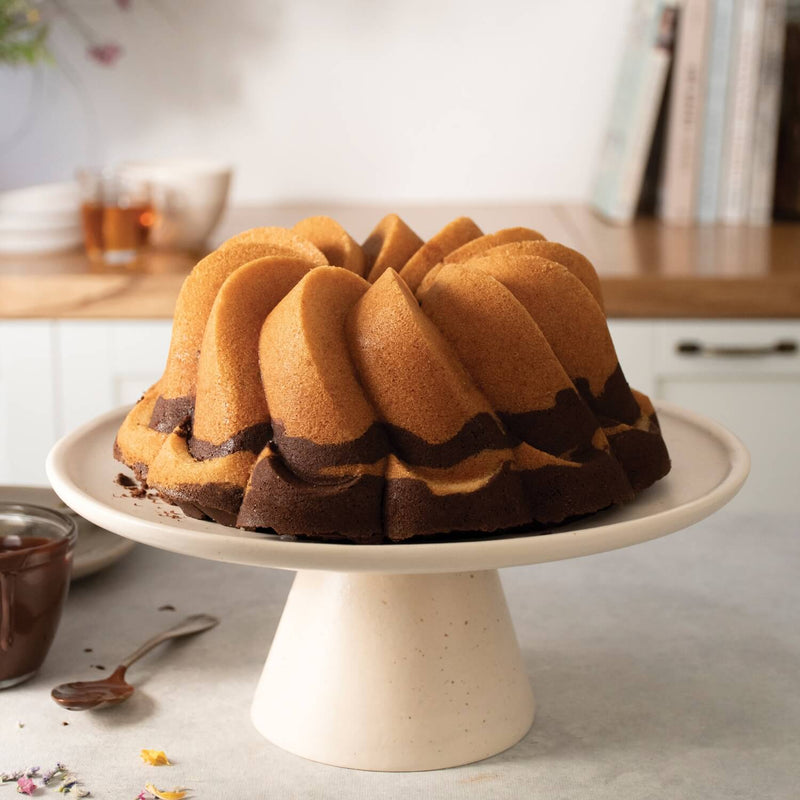 https://www.potterscookshop.co.uk/cdn/shop/files/96377-Nordic-Ware-Pirouette-Bundt-Pan-Gold-Lifestyle_800x.jpg?v=1696857327