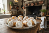 six cream horns filled with cream on a plate in a country kitchen
